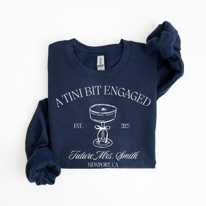 A navy blue sweatshirt with white text and graphics printed on it.