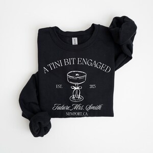 A black t-shirt with white text and graphics printed on it.