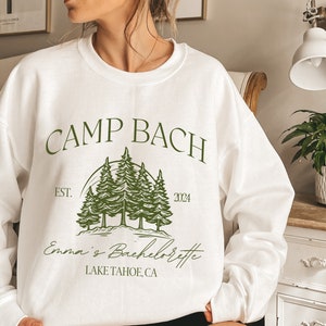 a woman in a white sweatshirt stands in a room