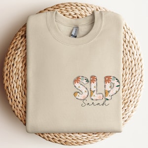 a white t - shirt with the word sls on it