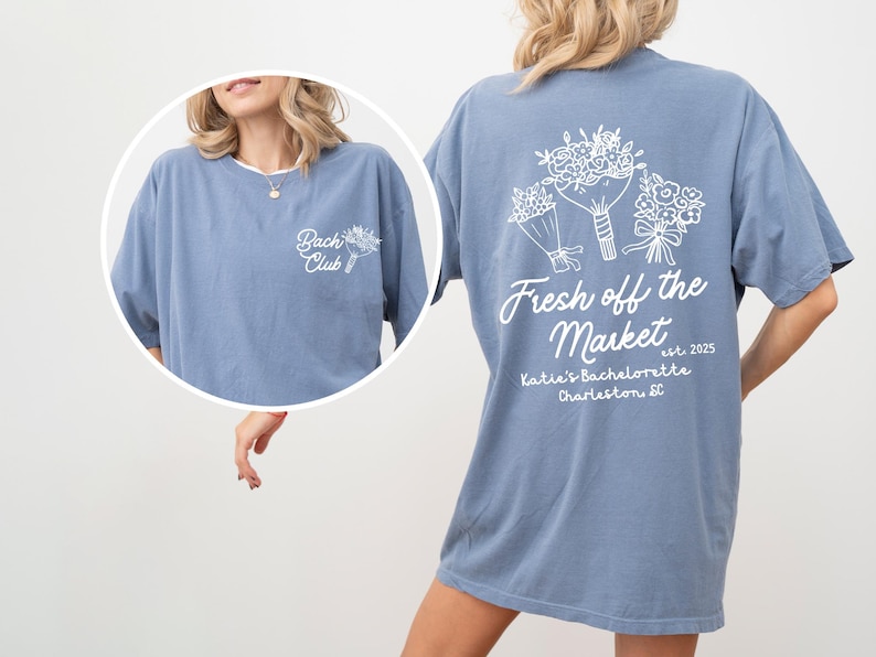 Może przedstawiać: Jasnoniebieska koszulka z białym nadrukiem kwiat&oacute;w i tekstem "Fresh off the Market est. 2025 Katie's Bachelorette Charleston, SC".