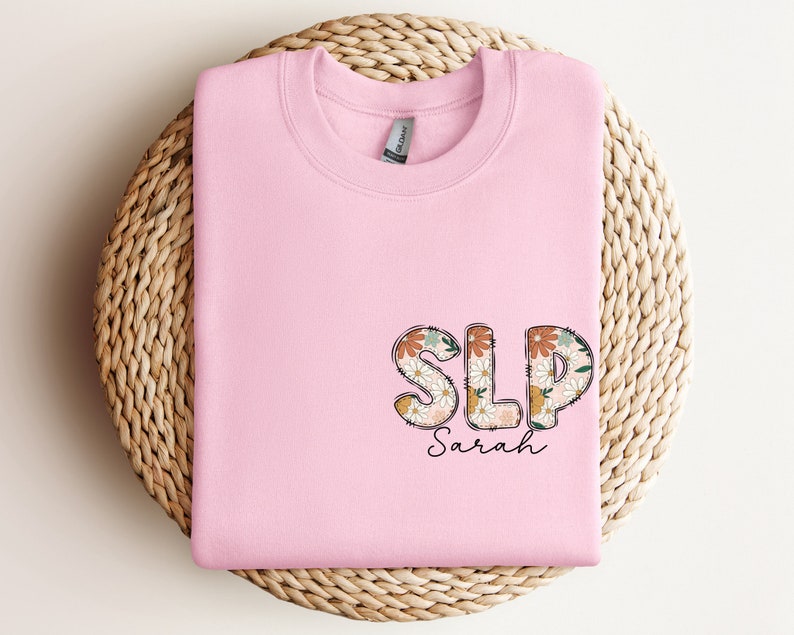 a pink shirt with the word slp spread on it