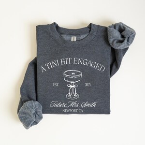 A gray sweatshirt with white text and graphics printed on it.