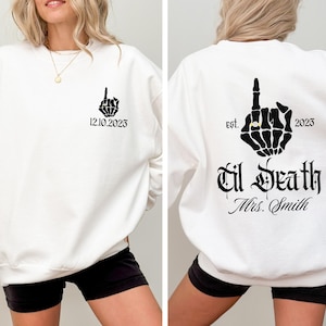 A white sweatshirt with black text and graphics on the back.