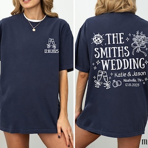 A woman wearing a navy blue t-shirt with white text and graphics printed on the back.