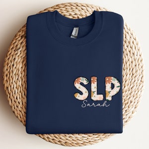a blue shirt with the word slp on it