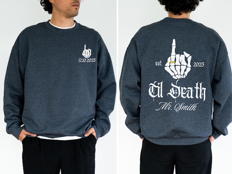 A man wearing a grey sweatshirt with white text and graphics on the back.