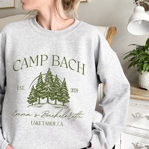a woman wearing a sweatshirt that says camp bach