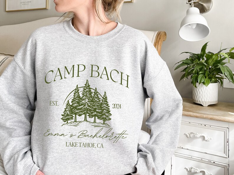 a woman wearing a sweatshirt that says camp bach
