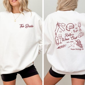 a woman wearing a white sweatshirt with the words the bride on it
