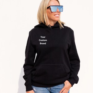 Puede incluir: Sudadera con capucha negra con un dise&ntilde;o de texto blanco que dice "Your Custom Brand".