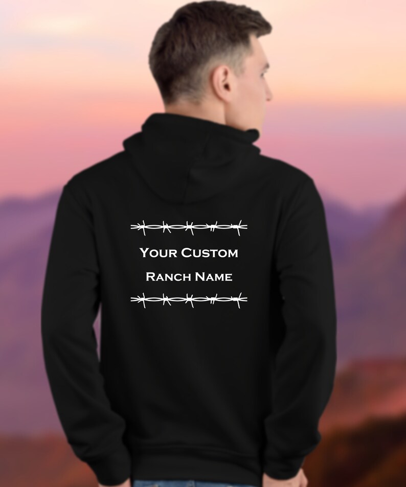 Puede incluir: Sudadera con capucha negra con un dise&ntilde;o de alambre de p&uacute;as blanco y el texto "YOUR CUSTOM RANCH NAME" en la espalda.