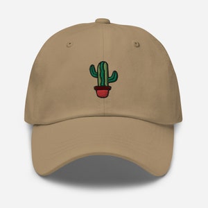 May include: A tan baseball cap with an embroidered green cactus in a red pot.