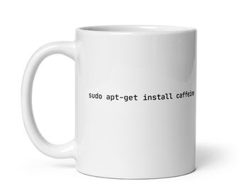Może przedstawiać: Biały ceramiczny kubek do kawy z nadrukiem "sudo apt-get install caffeine" na przodzie.