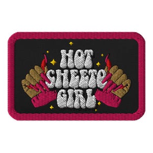 May include: Embroidered patch with a red border and black background. The patch features a white text design that says "Hot Cheeto Girl" with two pink hands with flames coming out of the fingertips.