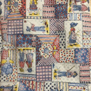 May include: A white fabric with a patchwork design featuring various patterns and colors, including red, blue, and yellow. The fabric is decorated with small figures of children wearing different outfits.
