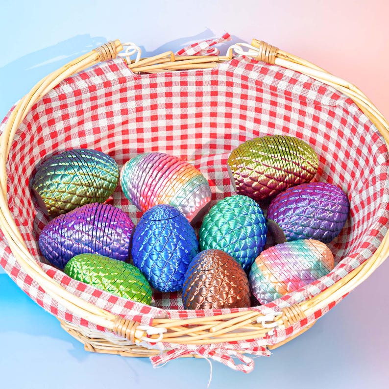 Puede incluir: Una cesta de mimbre con un forro a cuadros rojos y blancos contiene una colecci&oacute;n de huevos coloridos de aspecto met&aacute;lico. Los huevos son de varios colores, incluyendo azul, verde, morado y tonos arco&iacute;ris. La cesta es de madera tejida y tiene un asa.