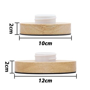 May include: Two wooden round bottle stoppers with a white plastic top. The larger stopper measures 12 cm in diameter and the smaller stopper measures 10 cm in diameter. Both stoppers are 2 cm in height.