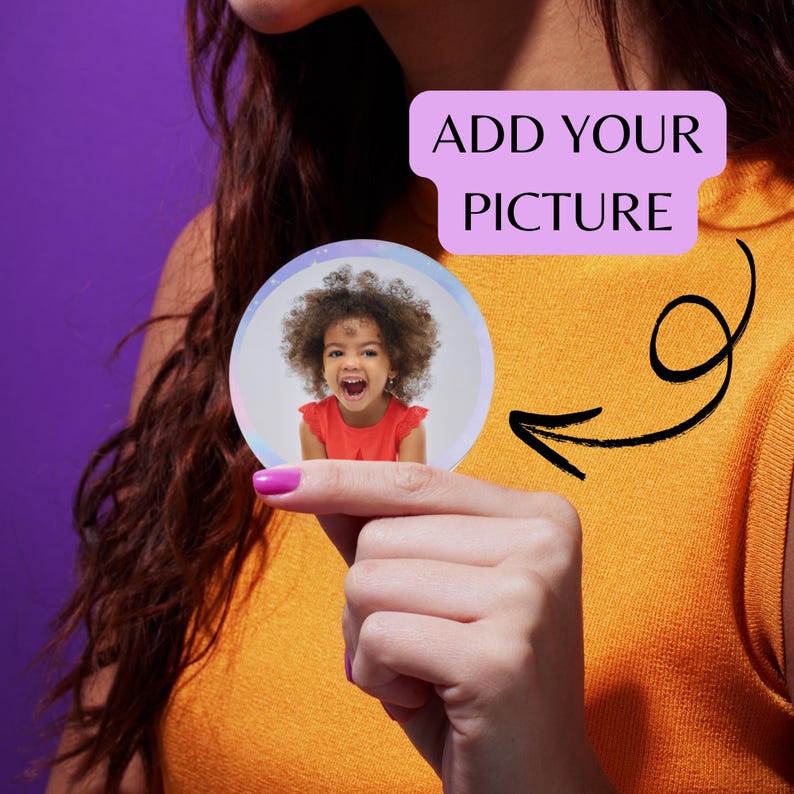 May include: A round, clear button with a photo of a child in a red shirt. The button is held up by a person's hand. The text "ADD YOUR PICTURE" is in a purple rectangle.