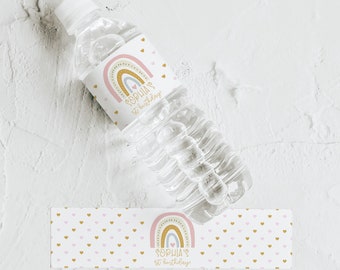 Könnte beinhalten: Wasserflaschenetikett mit einem Regenbogen-Design und rosa und goldenen Herzen. Das Etikett lautet "Sophia's 1st Birthday!"