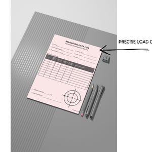 May include: A pink "Reloading Data Log" sheet with a target graphic, pens, and a pencil. The text "Precise Load Data" is next to the sheet. The sheet has a table for recording data. The pens and pencil are gray.