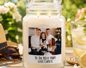 May include: A large clear glass jar candle with two wicks and white wax. The front label features a colour photograph of a family of four and the printed text: To The Best Mum Love Lucy X. The candle is filled with white wax and has a glass lid.
