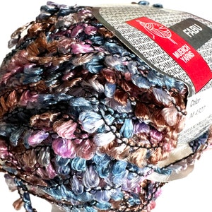 May include: A ball of multi-colored yarn with a brown, blue, pink, and white color scheme. The yarn is labeled "FABU" and "MUENCH YARNS" with the color number "M4327".