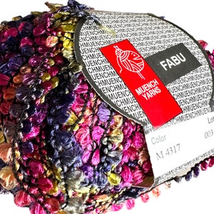 May include: A skein of multicolored yarn with a label that reads "FABU" and "Muench Yarns". The label also includes the color code "M 4317" and the lot number "003".