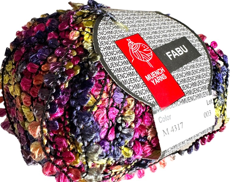 May include: A skein of multicolored yarn with a label that reads "FABU" and "Muench Yarns". The label also includes the color code "M 4317" and the lot number "003".
