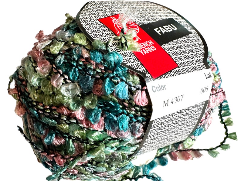 May include: A ball of green, pink, and blue yarn with a black thread running through it. The yarn has a fuzzy texture and is wrapped around a white label with the text "FABU" and "ENCH YARNS" in red. The label also has the text "Color M 4307" and "Lot 006".