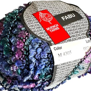 May include: A ball of blue, purple, and green yarn with a label that says "FABU" and "MUENCH YARNS". The label also includes the color code "M 4305" and the lot number "007".