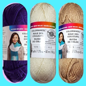 May include: Three skeins of yarn in purple, cream, and tan. Each skein has a label that reads "Colorwheel" and "Loops & Threads". The label also includes the yarn weight, length, and other details in both English and Spanish.