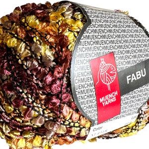 May include: A ball of yarn in shades of brown, orange, and yellow with a black and white pattern. The yarn is labeled "FABU" and "MUENCH YARNS".