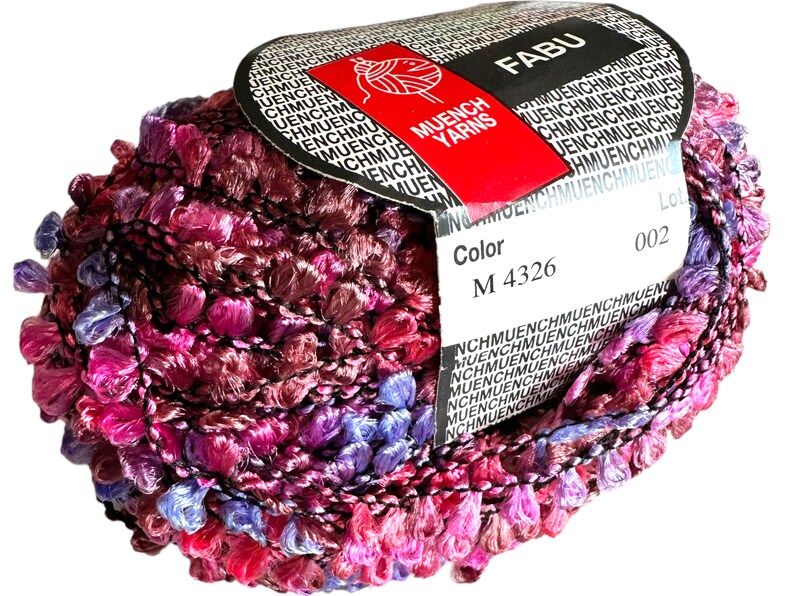 May include: A skein of pink, purple, and blue yarn with a black label that reads "FABU" and "MUENCH YARNS". The label also includes the color code "M 4326" and the lot number "002".