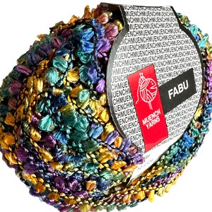 May include: A skein of multicoloured yarn with a fringe. The yarn is a mix of purple, teal, gold, and black. The label reads "FABU" and "MUENCH YARNS".