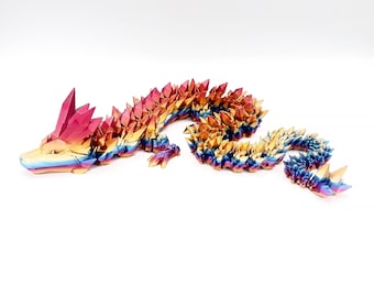 May include: A colorful, articulated dragon figurine. The dragon is made of iridescent material, with a gradient of colors including pink, gold, and blue. The dragon's body is segmented, allowing for flexible posing. The figurine is on a white background.