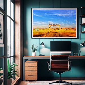 May include: A teal blue home office with a desk, a computer, a chair, and a framed landscape photograph of a wooden gate with the text "Circle View Ranch" above it.
