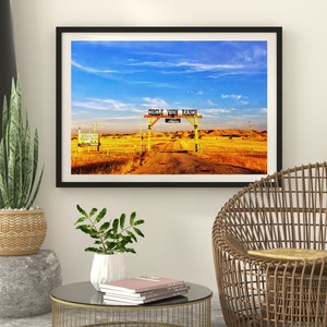 May include: A framed photograph of a rustic wooden gate with the words "Circle View Ranch" painted on it. The gate is open and leads to a dirt road that goes through a field of golden grass. The sky is blue with white clouds.