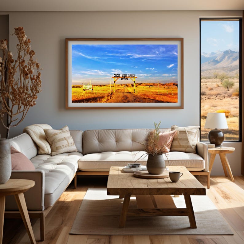 May include: A framed photograph of a ranch entrance with a wooden sign that reads "Circle Y Cow Ranch". The sign is over a dirt road leading into a field of long grass. The sky is blue with white clouds.