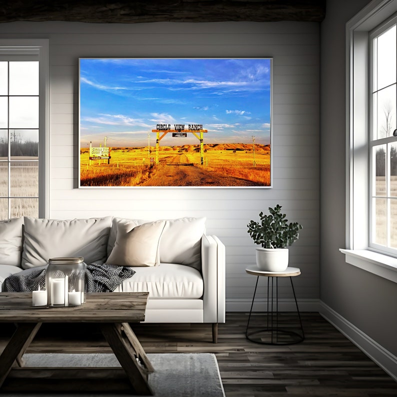 May include: A yellow wooden sign with the text "Circle View Ranch" on a dirt road in a field of dry grass under a blue sky with white clouds.