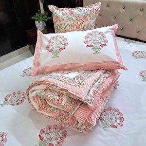 Quilted floral coverlet in blush pink tones layered with neutral boho bedroom styling