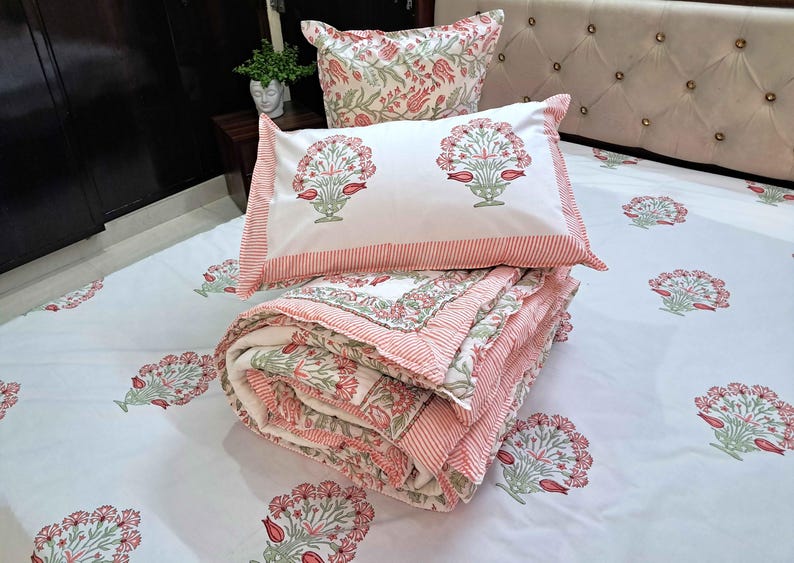 Quilted floral coverlet in blush pink tones layered with neutral boho bedroom styling