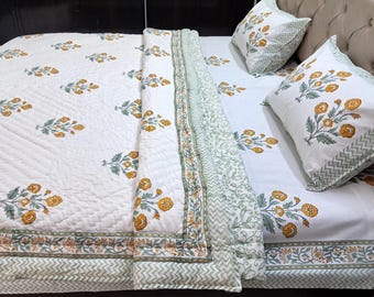 May include: White floral patterned bedding set with a quilt, two pillowcases, and a bedsheet. The design features yellow flowers and green leaves on a white background. The quilt and pillowcases have a decorative border.