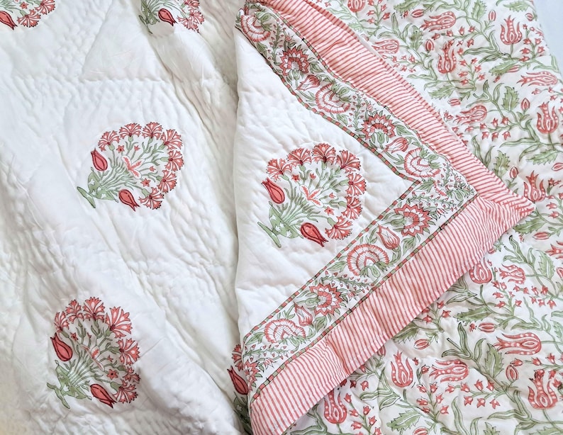 Handmade blush pink and green floral block print cotton quilt styled on cottage core bedroom bed