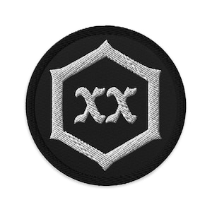 May include: Black and white embroidered patch with a hexagonal shape and the letters "XX" in a stylized font.