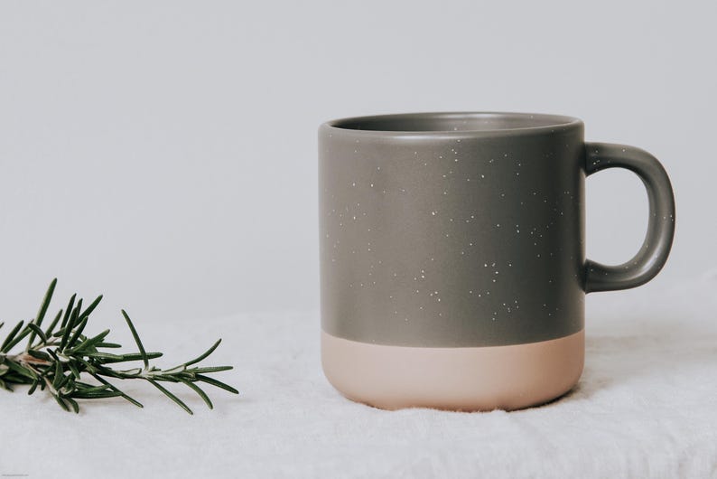 Eine stilvolle Keramiktasse in elegantem Schwarz und, ruht auf einem weichen Tuch. Perfekt für gemütliche Momente und eine liebevolle Geschenkidee. Bringen Sie Wärme und Stil in Ihre Kaffeepause mit diesen einzigartigen Tassen. Ideal für besondere Anlässe und alltäglichen Genuss.