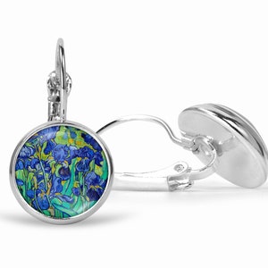 Puede incluir: Un par de pendientes de plata con cierre de palanca que presentan cabujones circulares con un estampado floral azul y verde vibrante inspirado en los Lirios de Van Gogh. Los engastes son de plata pulida y tienen un cierre articulado.