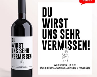 May include: A black and white wine bottle label with the text "DU WIRST UNS SEHR VERMISSEN!" and a peace sign. The label also includes the text "WAR SCHÖN MIT DIR! DEINE EHEMALIGEN KOLLEGINNEN & KOLLEGEN".