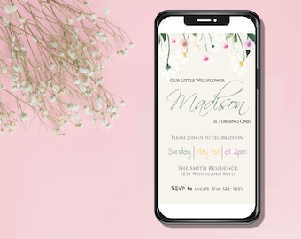 May include: A digital invitation for a first birthday party with a floral theme. The invitation features a white background with a floral border and the text "Our Little Wildflower Madison is Turning One!"  Please join us to celebrate on Sunday, May 1st at 2pm. The Smith Residence, 1234 Woodland Blvd. RSVP to Nicole 340-123-1234.