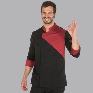 Può includere: Una giacca da chef nera e rossa con un design a contrasto. La giacca ha un colletto alla coreana e maniche lunghe.